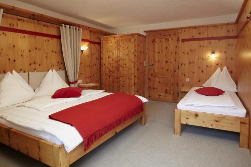 a bedroom with two beds and wooden walls at Moosbauerhof in Bad Kleinkirchheim