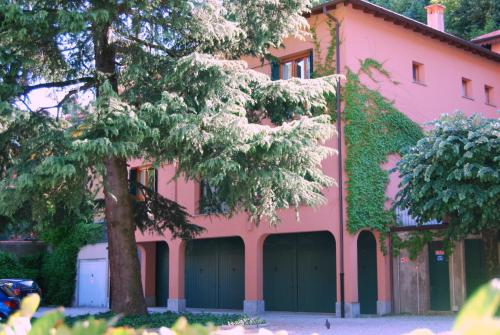 a pink building with a tree in front of it at Cernobbio Residence in Cernobbio