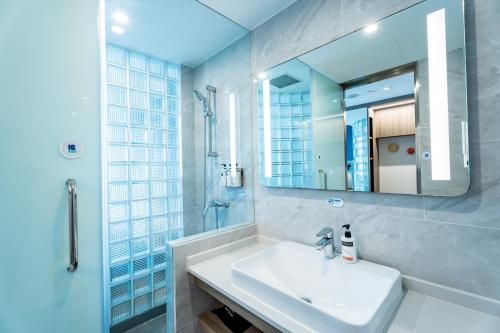 W białej łazience znajduje się umywalka i lustro. w obiekcie Holiday Inn Express Shanghai Jinqiao Central, an IHG Hotel w Szanghaju