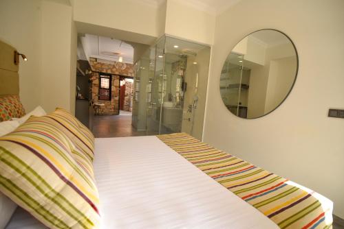 a bedroom with a bed with a mirror on the wall at Lovely Garden Flat with Patio near Hadrian's Gate in Antalya