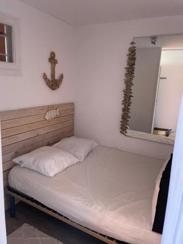 Appartement vue mer في لو باركار: سرير في غرفة مع مرآة