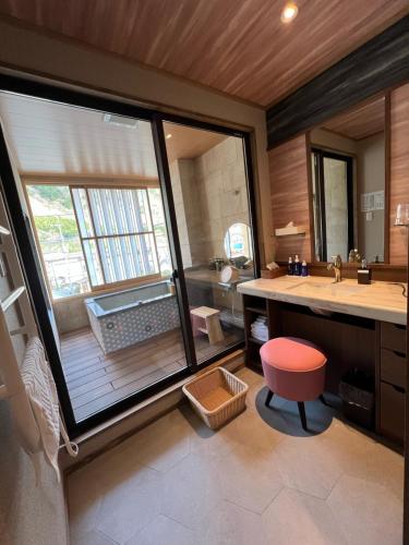 a bathroom with a sink and a large window at Marukyoo in Nikko