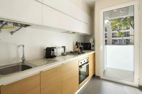 a kitchen with white cabinets and a sink at 1 Bed Apartment Sleeps 4 with Pool in Santo António