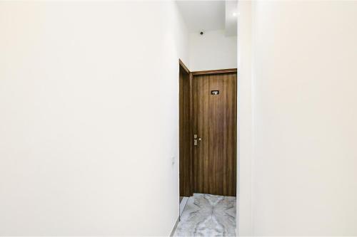 a hallway with a wooden door in a room at FabHotel Yellow Leaf in Ludhiana