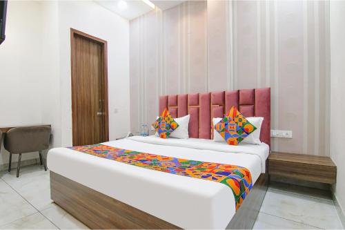 a bedroom with a large bed with a red headboard at FabHotel Yellow Leaf in Ludhiana
