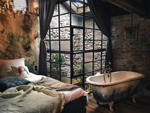 um quarto com uma banheira e uma janela em Rêve Aveyron em Broquiès