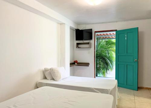 Habitación con 2 camas y puerta verde en Pacific Coast Hotel, en Playa Bonita Village