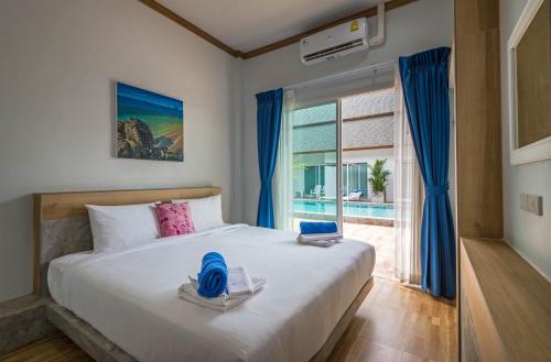 a bedroom with a bed and a large window at Amadha Villas Retreat - Free Tuk-Tuk Service To the Beach in Ao Nang Beach