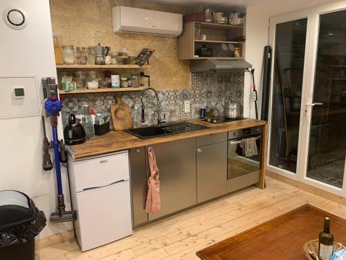 une cuisine avec un évier et un plan de travail dans l'établissement appartement cosy avec climatisation et patio centre historique de Bordeaux, à Bordeaux