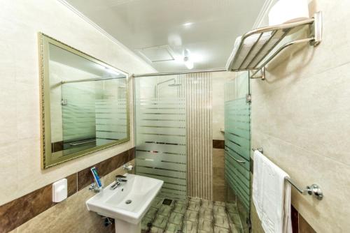 een badkamer met een wastafel en een douche met een spiegel bij Sea and Wave in Seogwipo