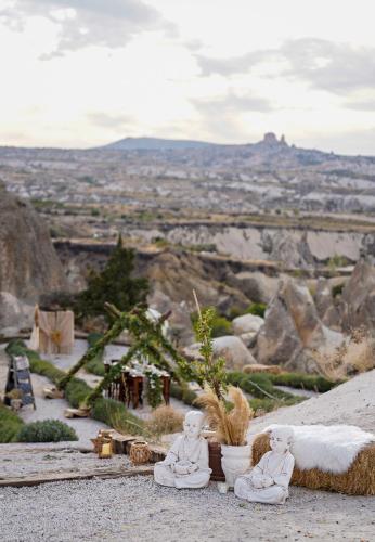 two statues of monks sitting on top of a mountain at Wish Cappadocia in Uchisar