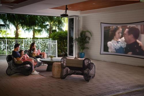 a group of people sitting on a porch watching a movie at Courtyard by Marriott Faro Blanco Resort in Marathon