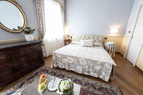 a bedroom with a bed and a mirror at Ristorante Albergo Ca' Vittoria in Tigliole