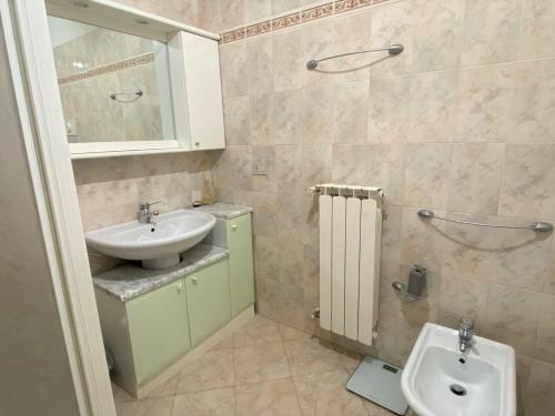 La salle de bains est pourvue d'un lavabo et de toilettes. dans l'établissement The Sunny Lake - Apartment with Pool, à Desenzano del Garda