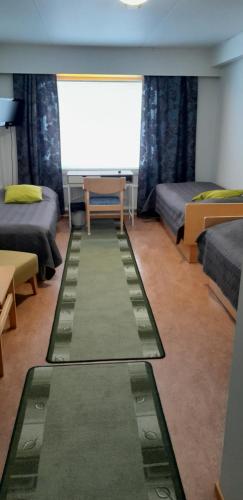 een kamer met twee bedden en een tafel erin bij Karemajat Panorama hotel in Ylitornio