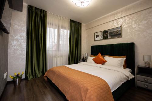 una camera da letto con un grande letto con tende verdi di Central Apartament 3 a Iaşi