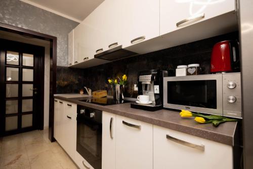una cucina con armadietti bianchi e forno a microonde di Central Apartament 3 a Iaşi