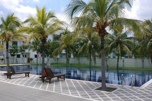 2 bancos y palmeras junto a una piscina en Setia Residen Semi-D 2.5 storey, unlimited wifi, en Sitiawan
