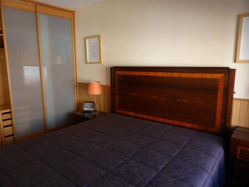 1 dormitorio con 1 cama con cabecero de madera en Apartment by the beach en Oporto