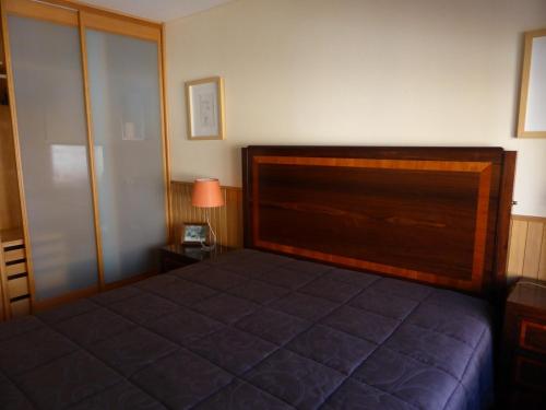 una camera da letto con un letto con testiera in legno di Apartment by the beach a Porto