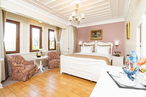 a bedroom with a white bed and a table and chairs at Alzer Hotel Special Class in Istanbul