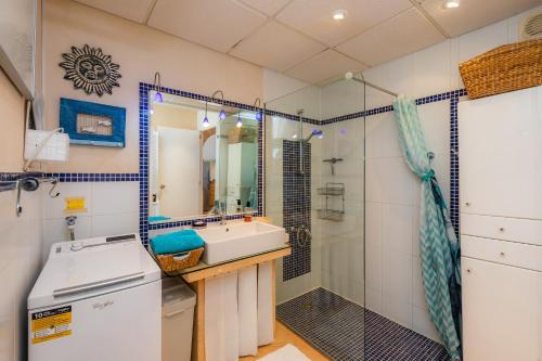 ein Bad mit einem Waschbecken und einer Dusche in der Unterkunft Strandwohnung Marina Park Playa in Cala Millor