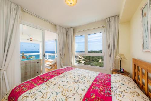 ein Schlafzimmer mit einem Bett und einem großen Fenster in der Unterkunft Strandwohnung Marina Park Playa in Cala Millor