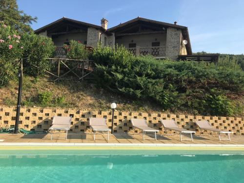una casa con sedie e una piscina di Villa Tilla a Gualdo Cattaneo