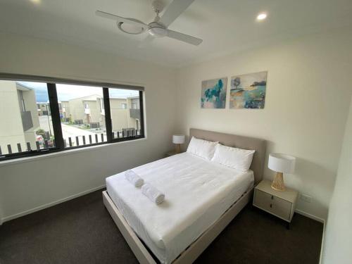 a white bedroom with a bed and a window at Stunning 2story villa Near Canal in Gold Coast