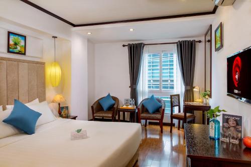 a hotel room with a bed and a desk at Babylon Grand Hotel & Spa in Hanoi