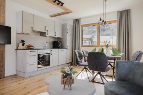 eine Küche und ein Wohnzimmer mit einem Tisch und Stühlen in der Unterkunft Apartment Streif LXL in Kirchdorf in Tirol