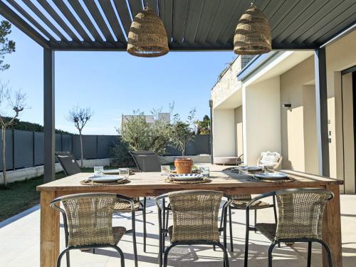 a patio with a wooden table and chairs at Villa Agapanto in Pacengo di Lazise