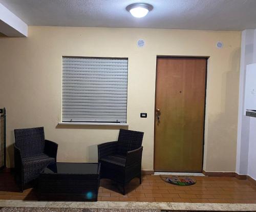 a waiting room with two chairs and a window at Confort home in Rende