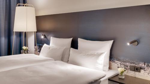 a bedroom with two beds with white pillows at Hotel the YARD Bad Honnef in Bad Honnef am Rhein