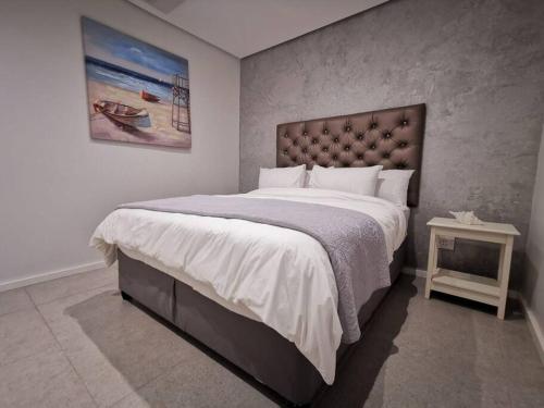 a bedroom with a large bed and a table at UNIT 33 OCEANDUNE in Umhlanga