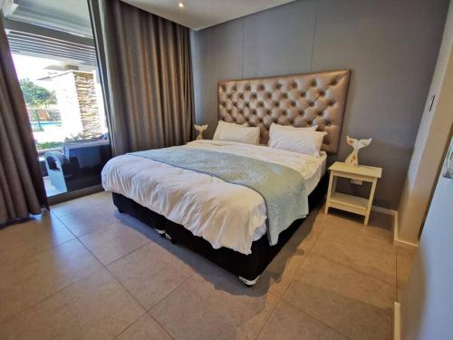 a bedroom with a large bed and a window at UNIT 33 OCEANDUNE in Umhlanga