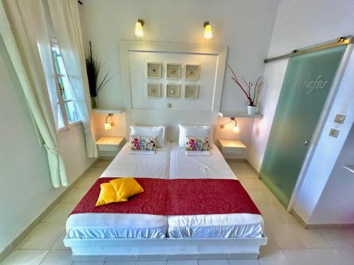 a bedroom with a white bed with a red blanket at Villa Zografos in Irakleia
