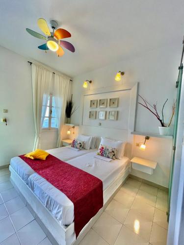 una camera da letto con un grande letto bianco con una coperta rossa di Villa Zografos a Heraklia (Iraclia)