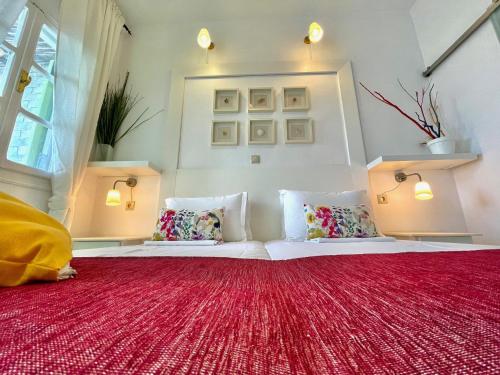 Habitación con 2 camas y alfombra roja. en Villa Zografos, en Iraklia