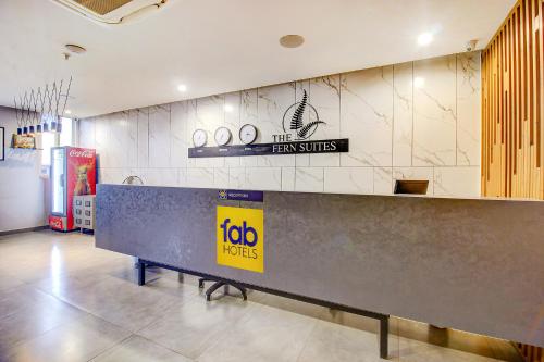 a reception desk in a store with a sign on the wall at FabHotel SSR Fern Suites in Lingampalli