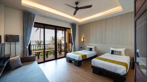 a hotel room with two beds and a balcony at Ban Saithong Beach Resort in Bang Saphan Noi