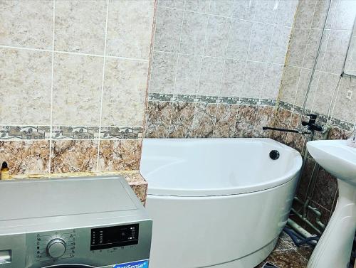 a bathroom with a white toilet and a sink at Однокомнатная квартира Авангард 2 in Atyrau