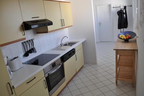 a kitchen with a sink and a bowl of fruit at Meerblick Apartment in Göhren