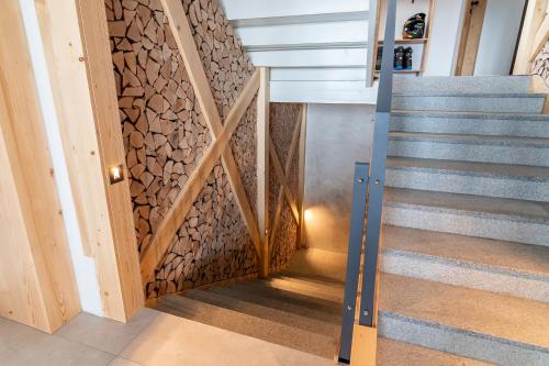 a staircase in a house with a stone wall at Ribniška koča in Ribnica na Pohorju