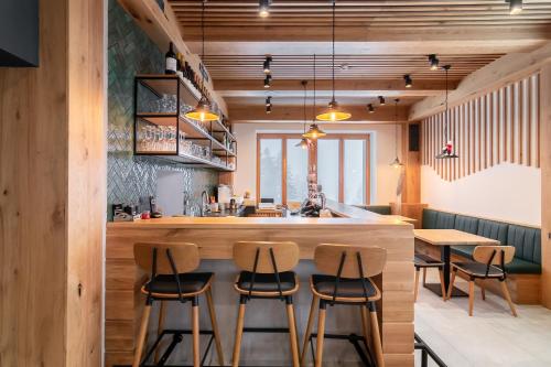 a kitchen with a bar with stools around it at Ribniška koča in Ribnica na Pohorju