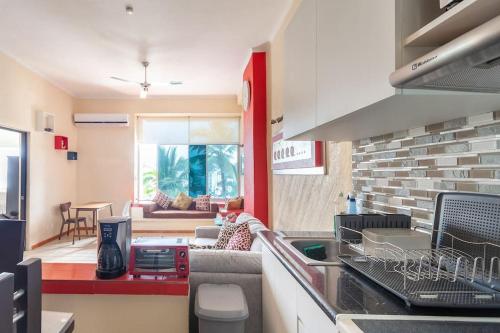 a kitchen with a counter and a living room at Apartamento amueblado en Acapulco in Acapulco