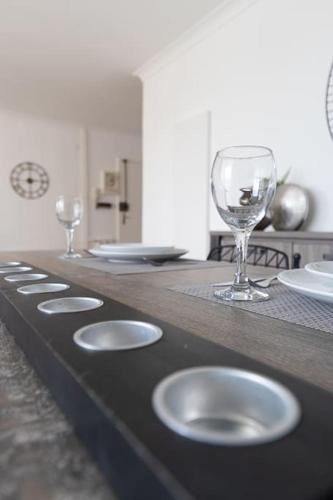 - un comptoir avec des verres à vin et des assiettes dans l'établissement Cabana & Le Grand Appartement Lumineux, à Mâcon