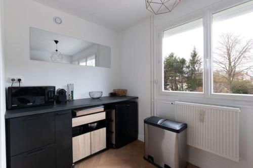 une cuisine avec un comptoir noir et une fenêtre dans l'établissement Cabana & Le Grand Appartement Lumineux, à Mâcon