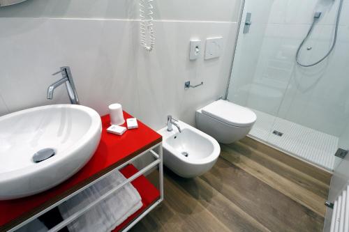 a bathroom with a white sink and a toilet at Hotel Aurea in Rimini