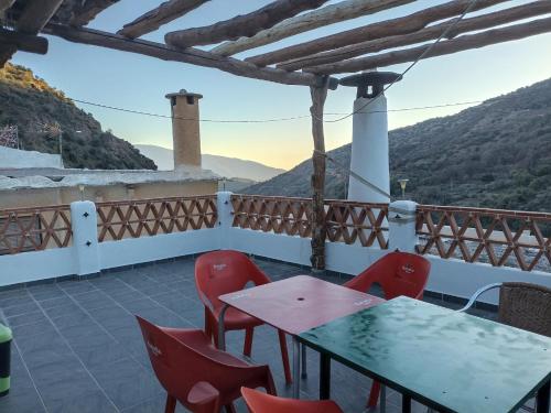 einen Tisch und Stühle auf einem Balkon mit Aussicht in der Unterkunft Casa Los Trillizos in Pampaneira